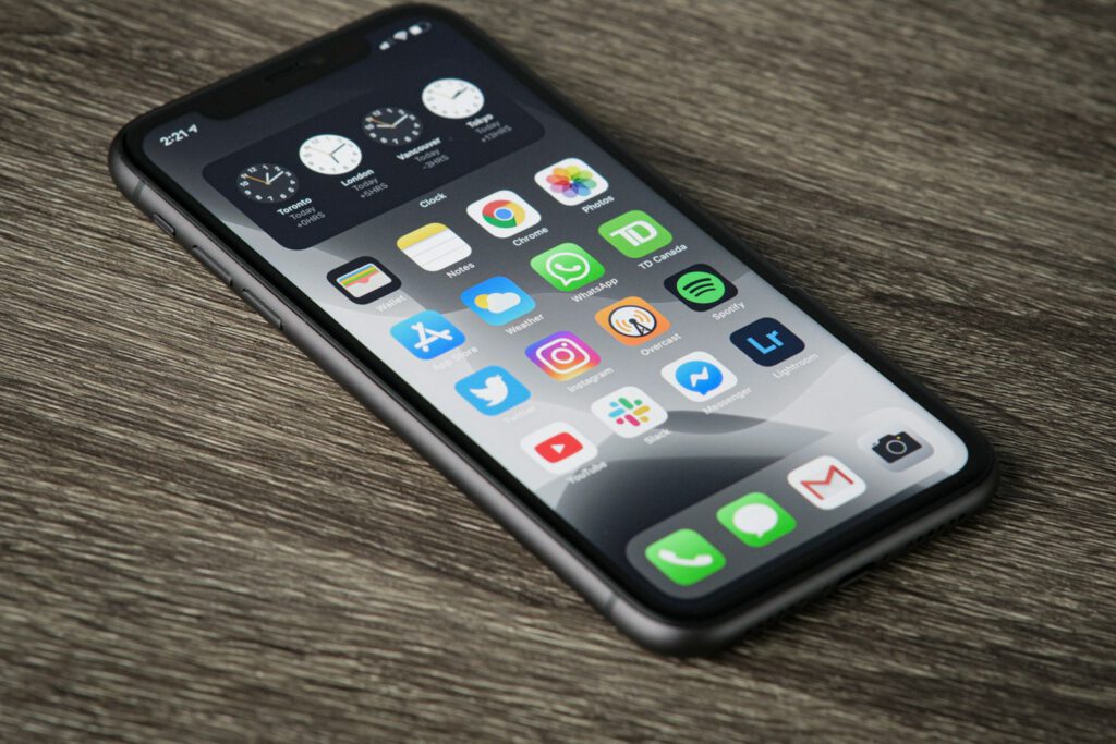Smartphone posé sur une table en bois – illustration de l’article « Applications mobiles : Flutter ou natif, que choisir en 2025 ? », blog Ionia Web