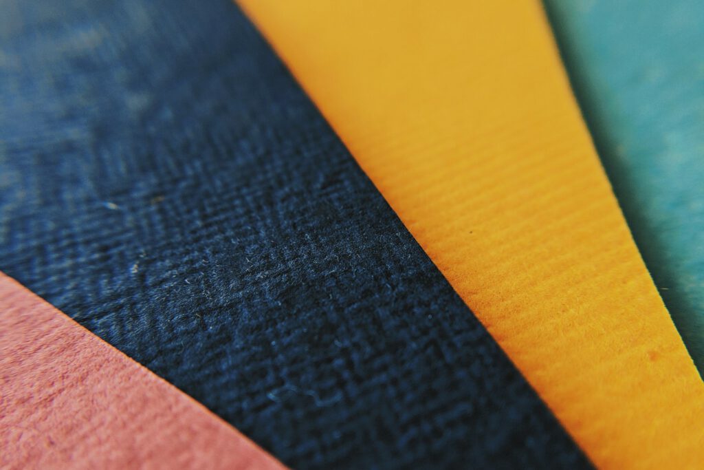 Échantillons de papiers colorés et texturés – illustration de l’article « Bien choisir le papier de vos cartes de visite », blog Ionia Web