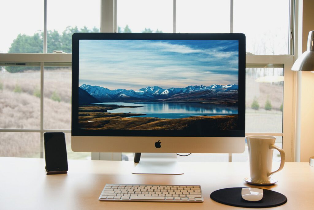 Ordinateur de bureau sur un bureau lumineux – illustration de l’article « Logiciel sur mesure ou logiciel du marché : comment décider ? », blog Ionia Web