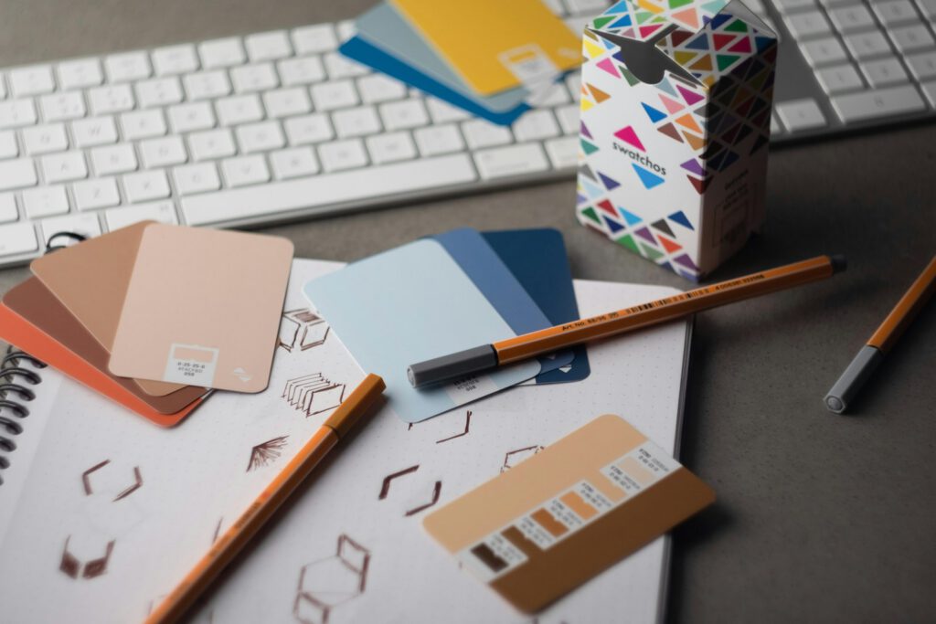 Échantillons de couleurs et croquis sur un bureau de designer – illustration de l’article « Charte graphique : le document que toute entreprise devrait avoir », blog Ionia Web