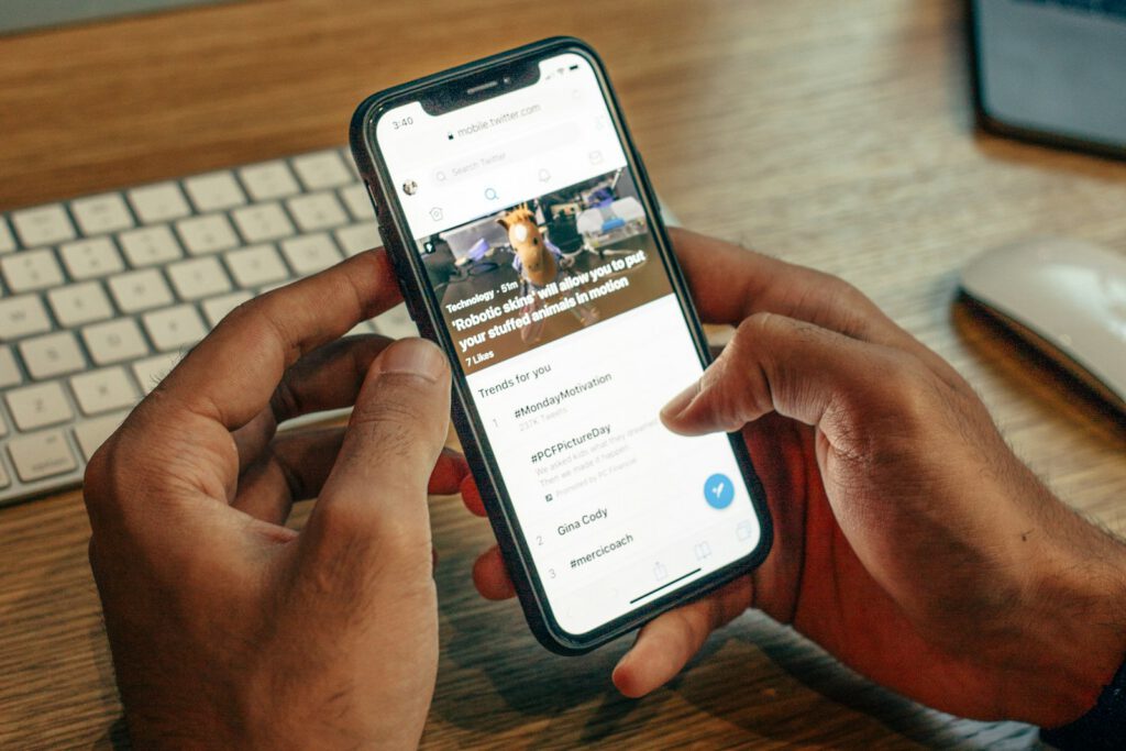 Site web consulté sur un smartphone tenu à deux mains – illustration de l’article « Pourquoi votre site doit être pensé d’abord pour le mobile », blog Ionia Web