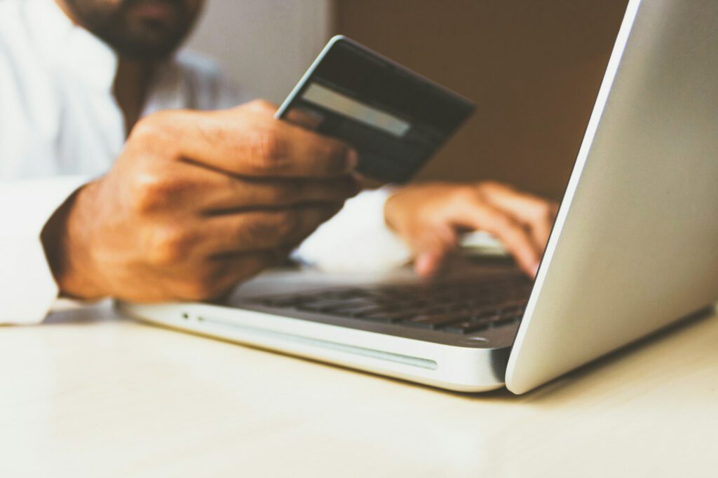 Paiement en ligne avec une carte bancaire devant un ordinateur portable – illustration de l’article « Paiement en ligne au Maroc : les solutions pour votre site », blog Ionia Web