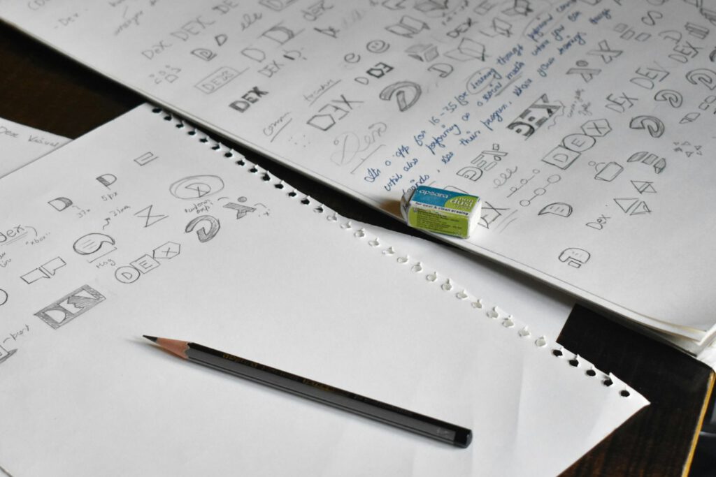 Croquis de recherche de logo sur un carnet – illustration de l’article « Identité visuelle : les étapes de création d’un logo », blog Ionia Web