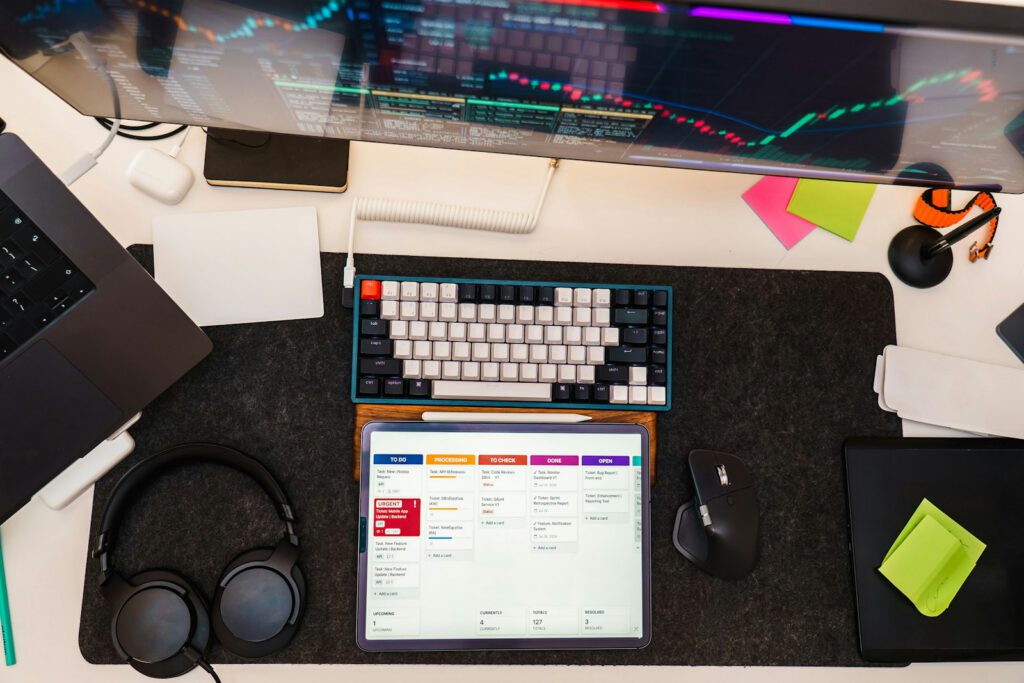 Poste de travail avec clavier, tablette et notes – illustration de l’article « Automatiser ses tâches répétitives grâce au logiciel », blog Ionia Web