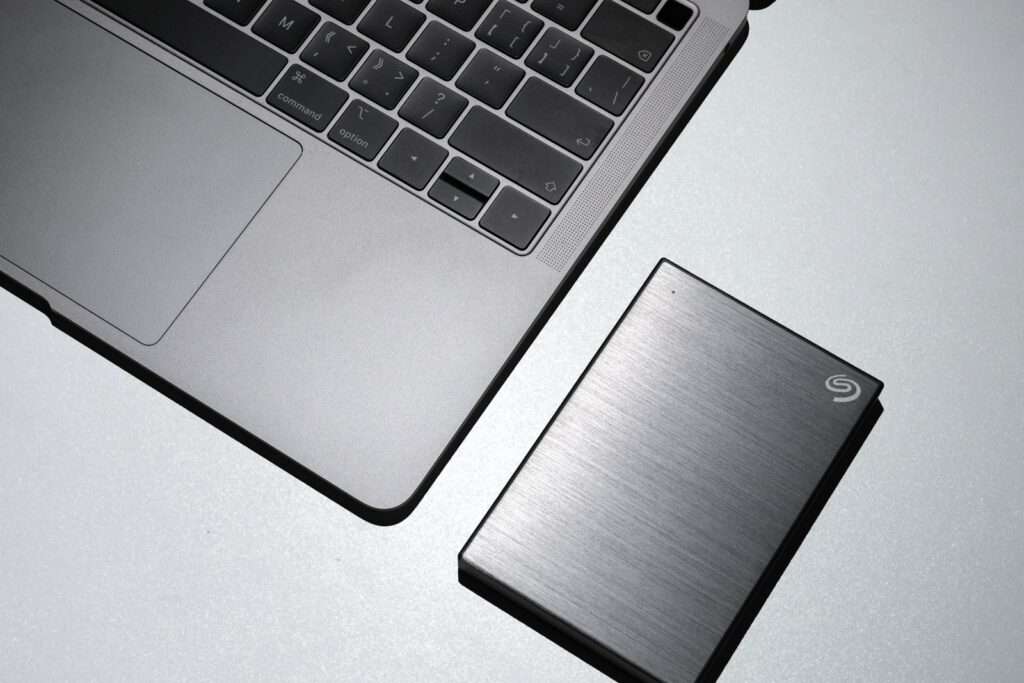 Disque dur externe posé à côté d’un ordinateur portable – illustration de l’article « Sauvegardes : la règle du 3-2-1 pour ne jamais perdre vos données », blog Ionia Web